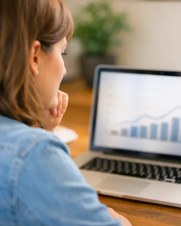 Business owner reviewing a financial growth chart on a laptop, representing the cash flow benefits of premium funding.