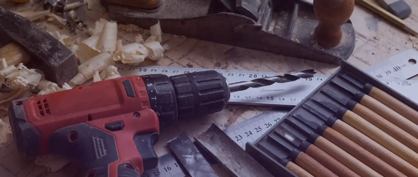 Professional carpenter operating a stationary drill press in a woodworking workshop to process timber.