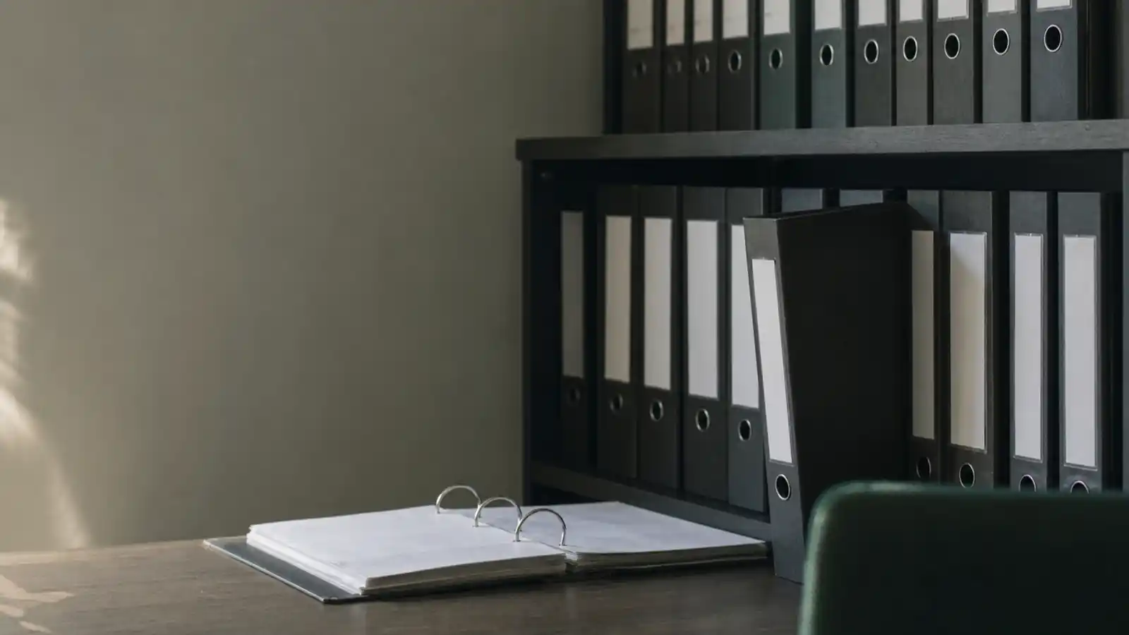 Shelved policy manuals in an office, professional indemnity insurance for compliance officers