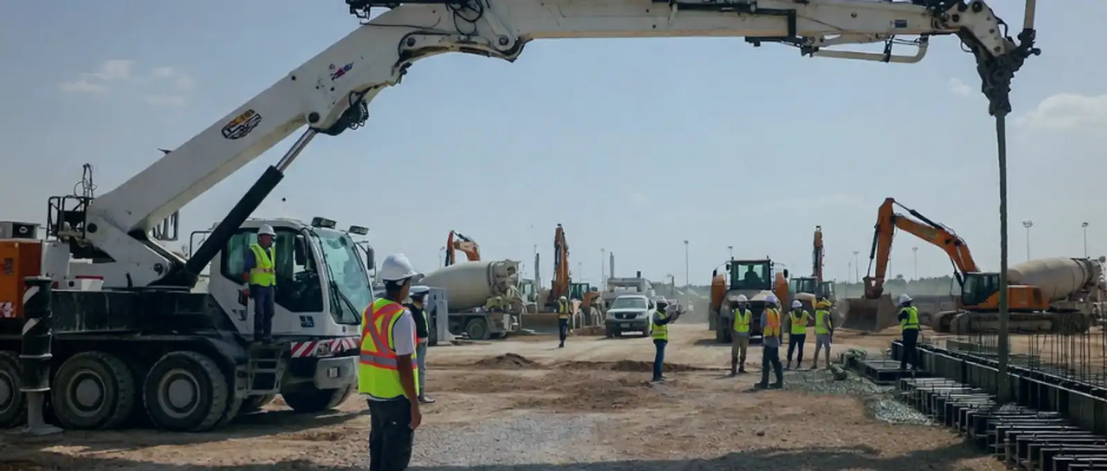 Sole trader concrete pump operator pouring cement on construction site with pump hose and safety equipment