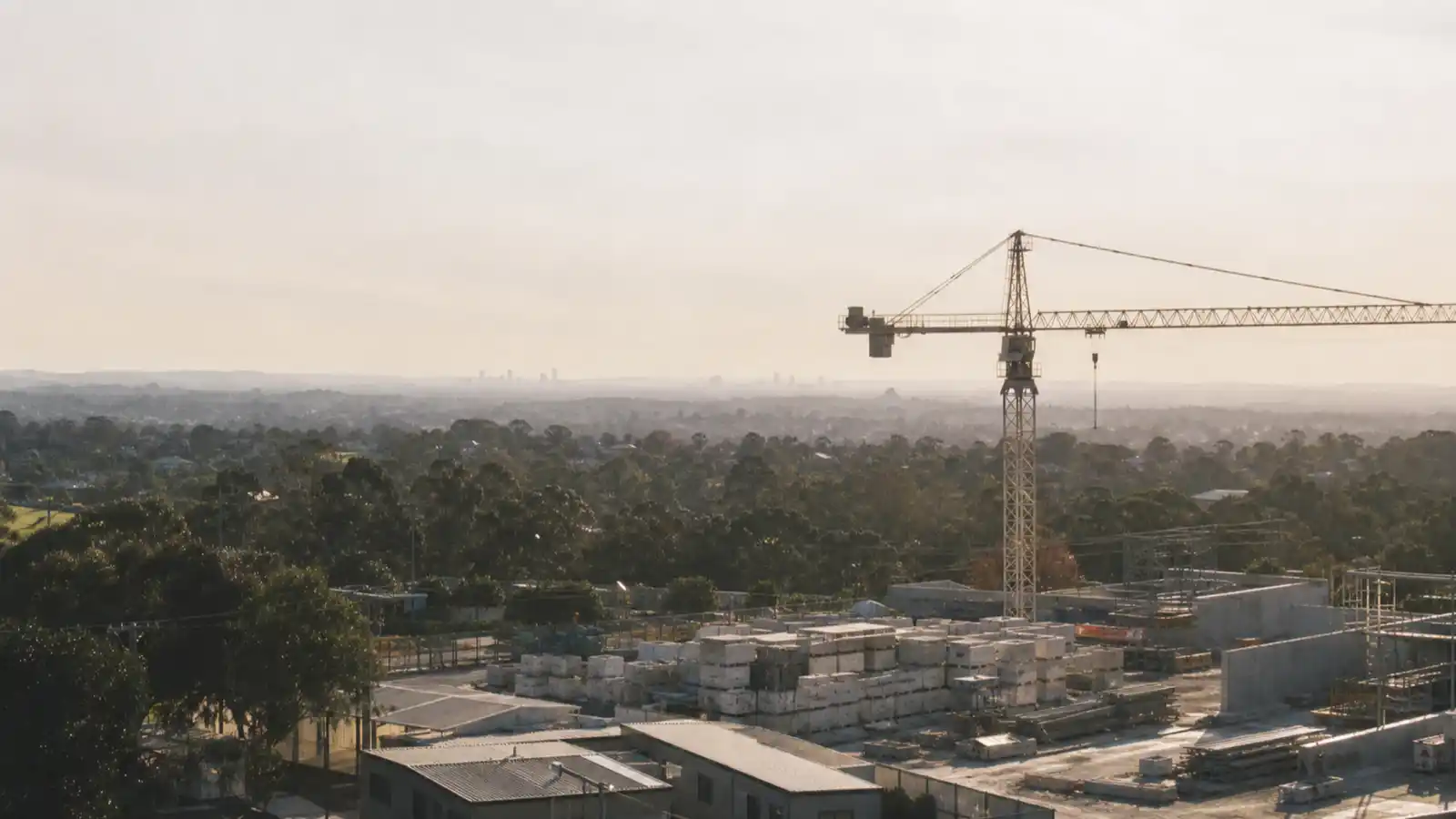 Construction site with tower crane at dawn, professional indemnity insurance for construction managers