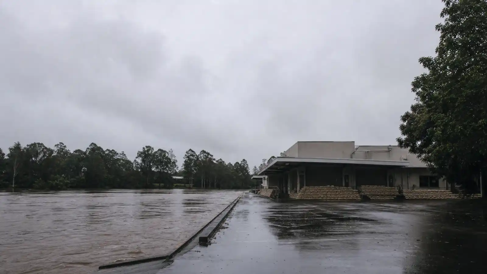Commercial building beside a river with sandbags at the dock, a flood-zone commercial property insurance risk