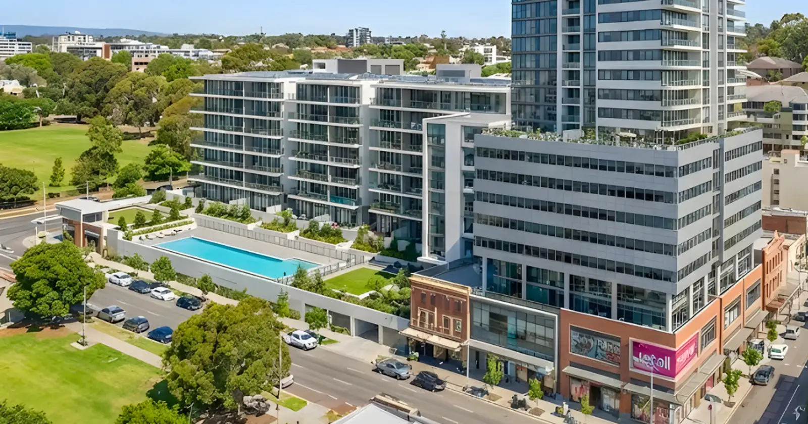 Modern multi-story mixed-use development with a vibrant rooftop garden, ground-floor commercial storefronts, and upper-level residential housing.