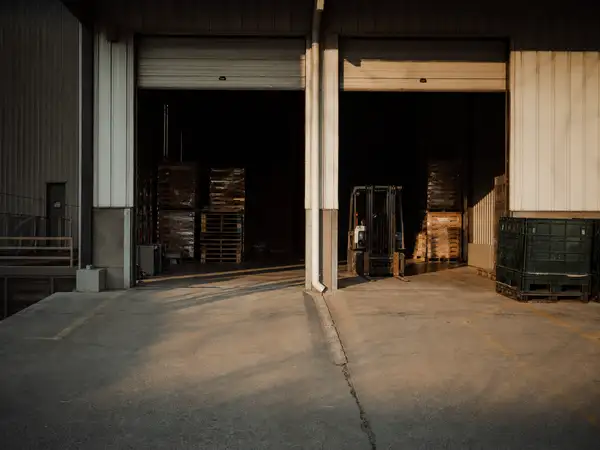 Factory loading dock with pallets and forklift, operations protected by an ISR insurance program