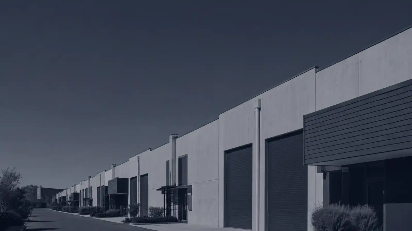 Row of strata industrial units with roller doors, industrial warehouse strata insurance