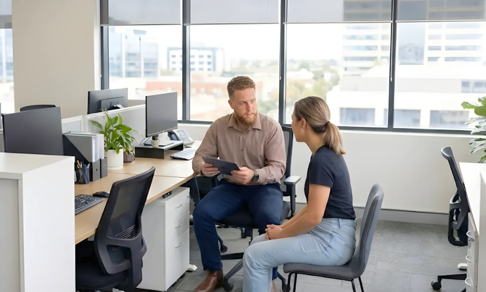 Insurance broker explaining plate glass insurance policy details to a business owner in an office setting