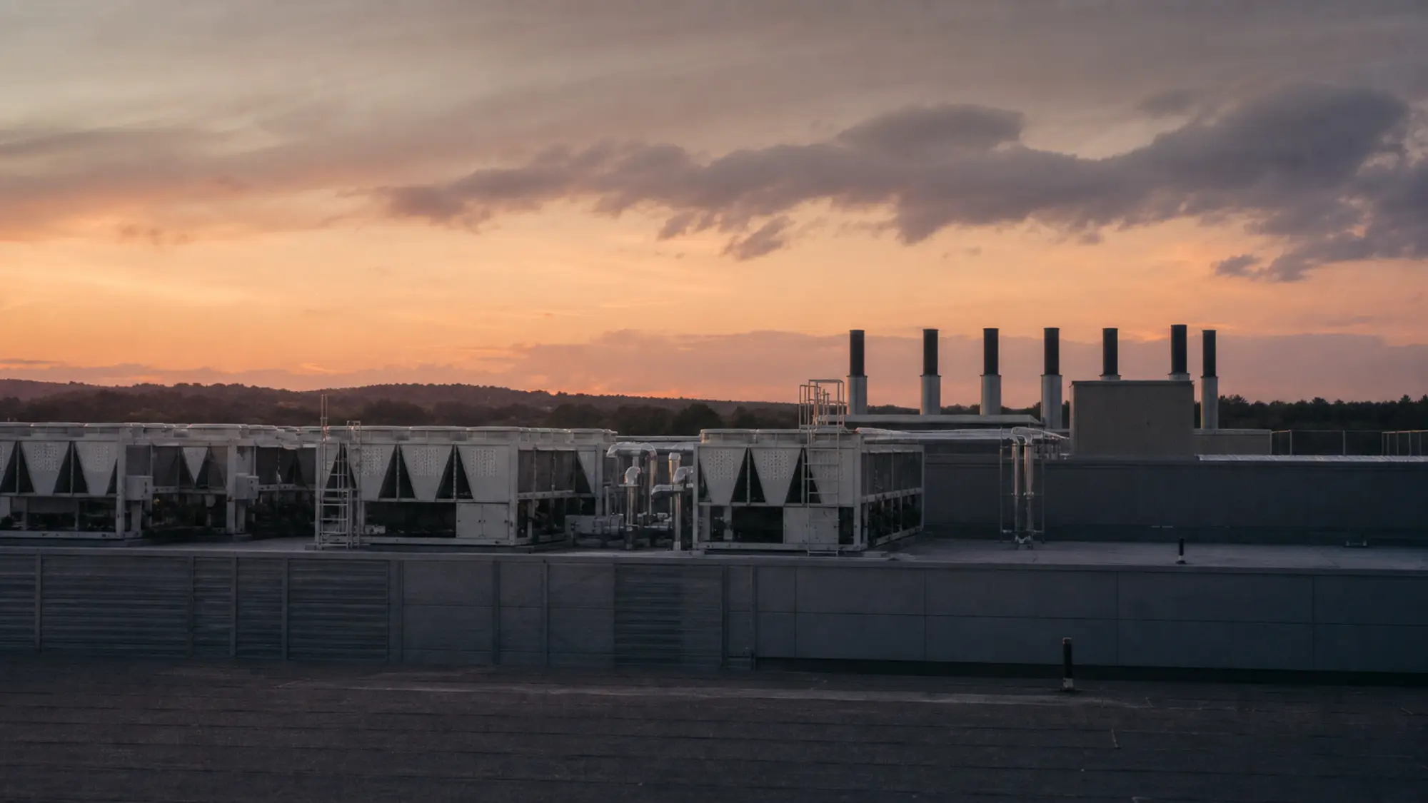 Rooftop cooling plant on a data centre at dusk, plant and machinery under ISR cover