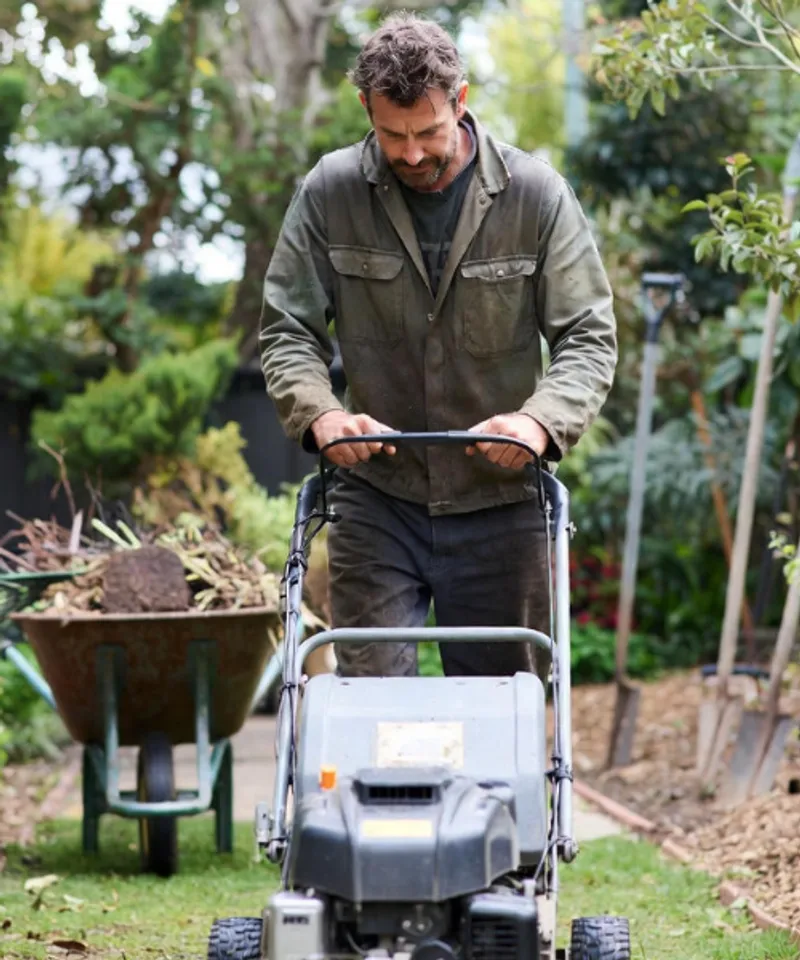 Professional landscaper operating commercial lawn mower in residential garden – public liability insurance for landscaping businesses Australia