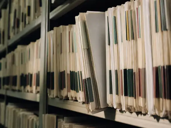 Tabbed practice records on shelving, part of presenting a healthcare risk to underwriters