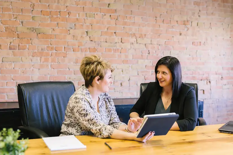 Two professionals discussing an insurance placement at a boardroom table.