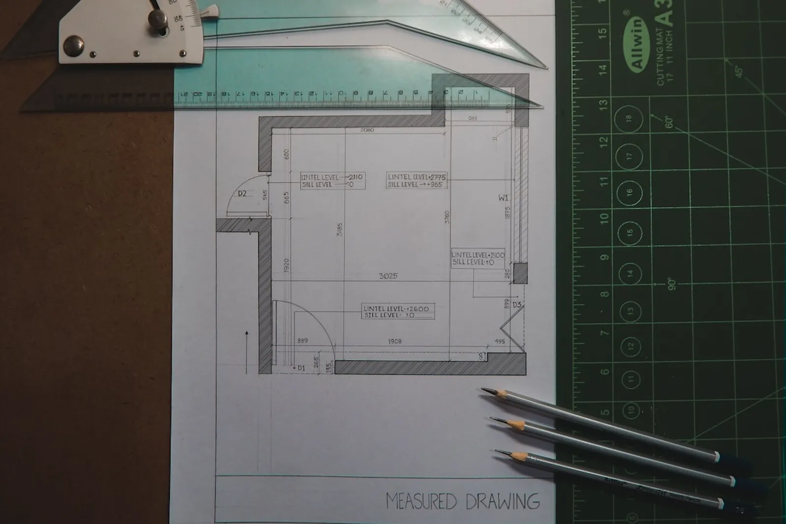 Technical floor plan drawing with ruler and pencils representing draftsperson professional work
