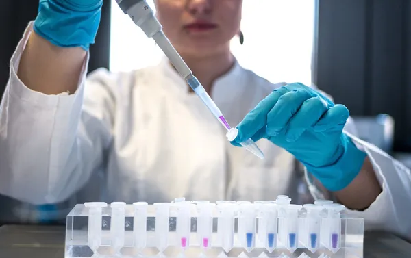 Biochemist examining test tubes and laboratory samples representing professional indemnity coverage