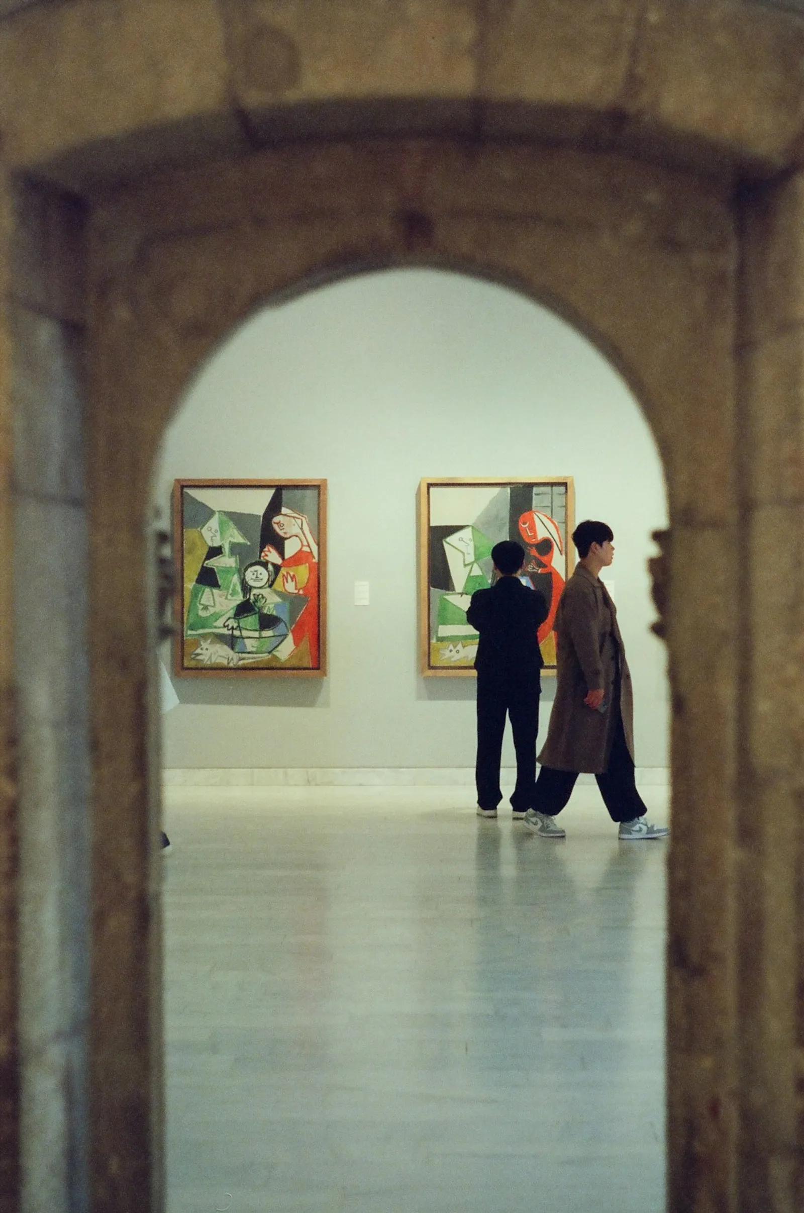 People observing paintings in an art gallery