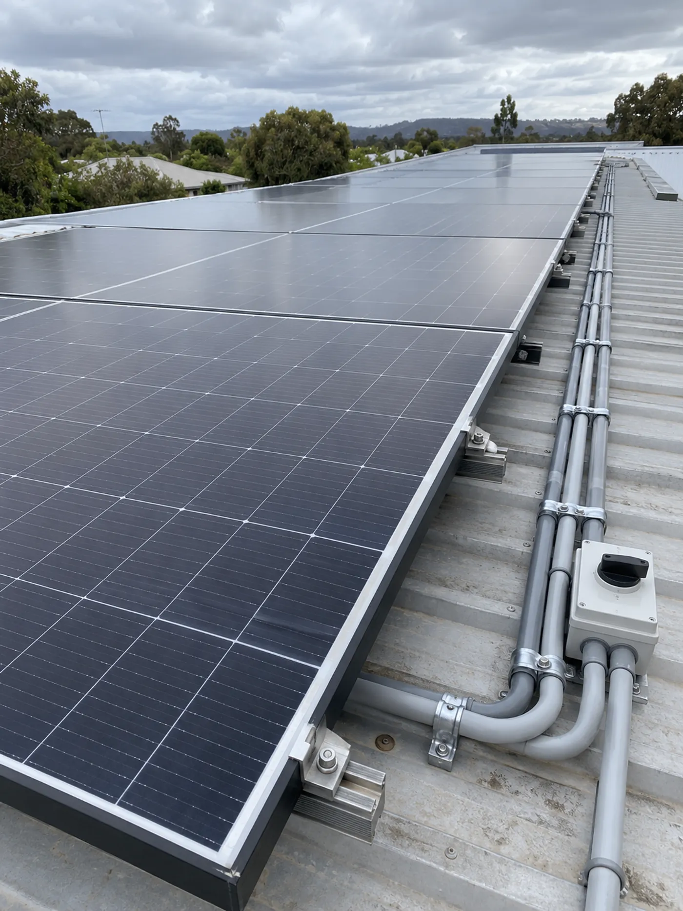Rooftop solar panels with conduit and a rooftop isolator on a metal roof