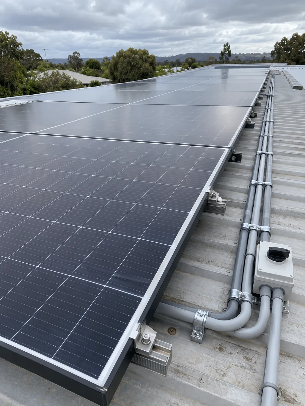 Rooftop solar panels with conduit and a rooftop isolator on a metal roof