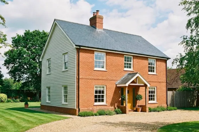 Traditional two-storey country house with brick and weatherboard cladding requiring comprehensive home building insurance.